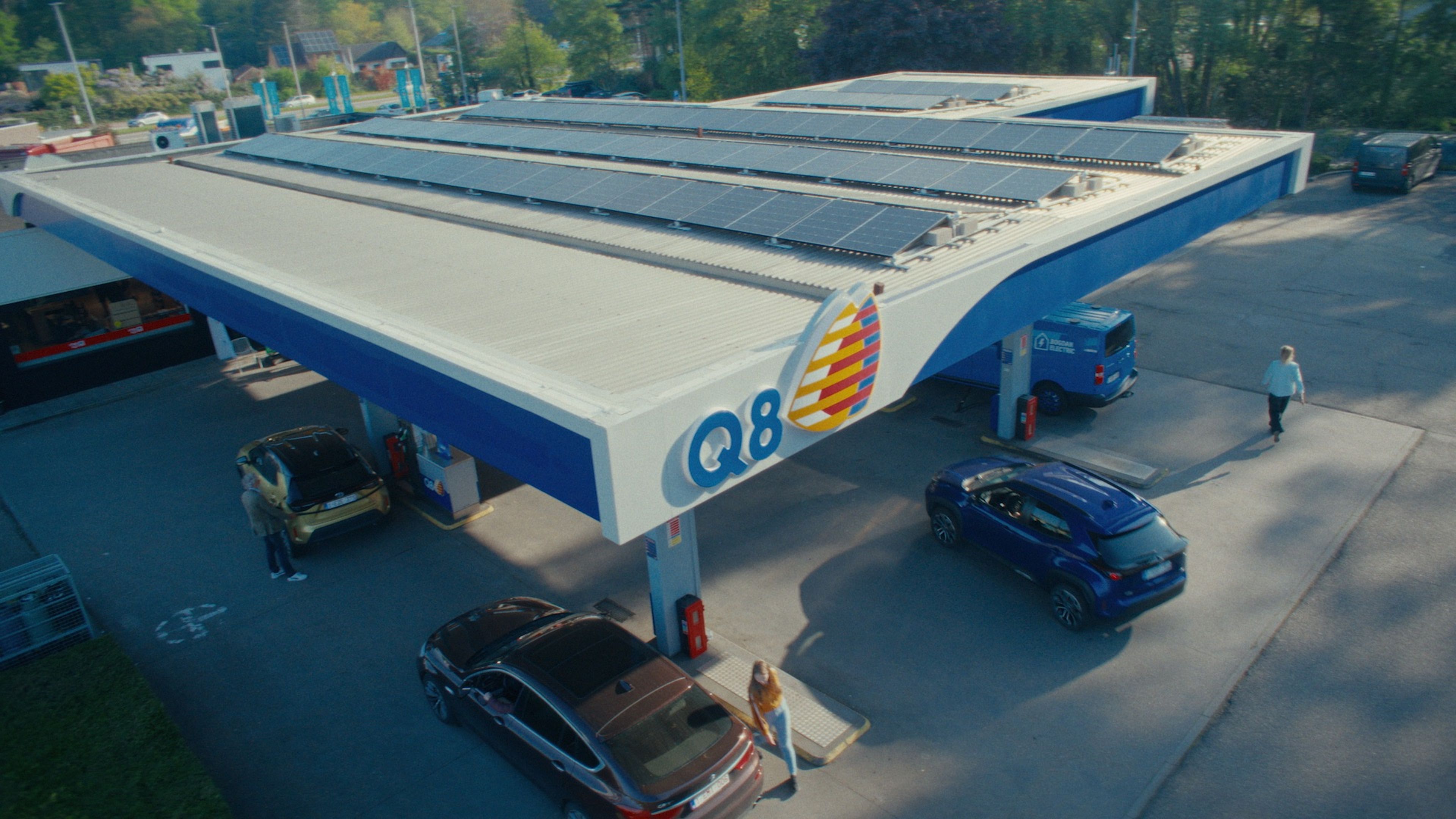 Bovenaanzicht Q8 tankstation met verschillende tankende auto's