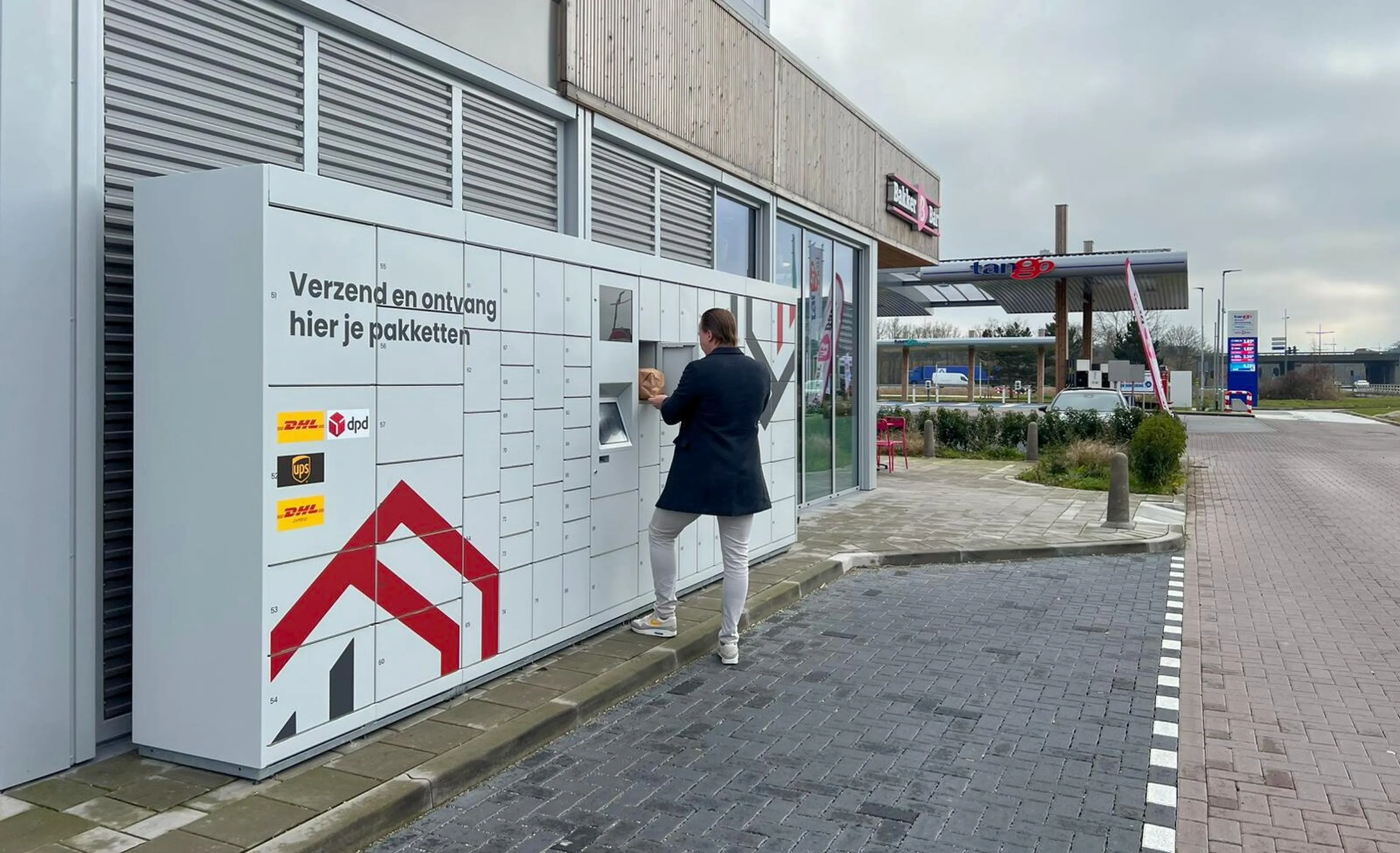 Man gebruikt een pakketwand van De Buren op Tango tankstation