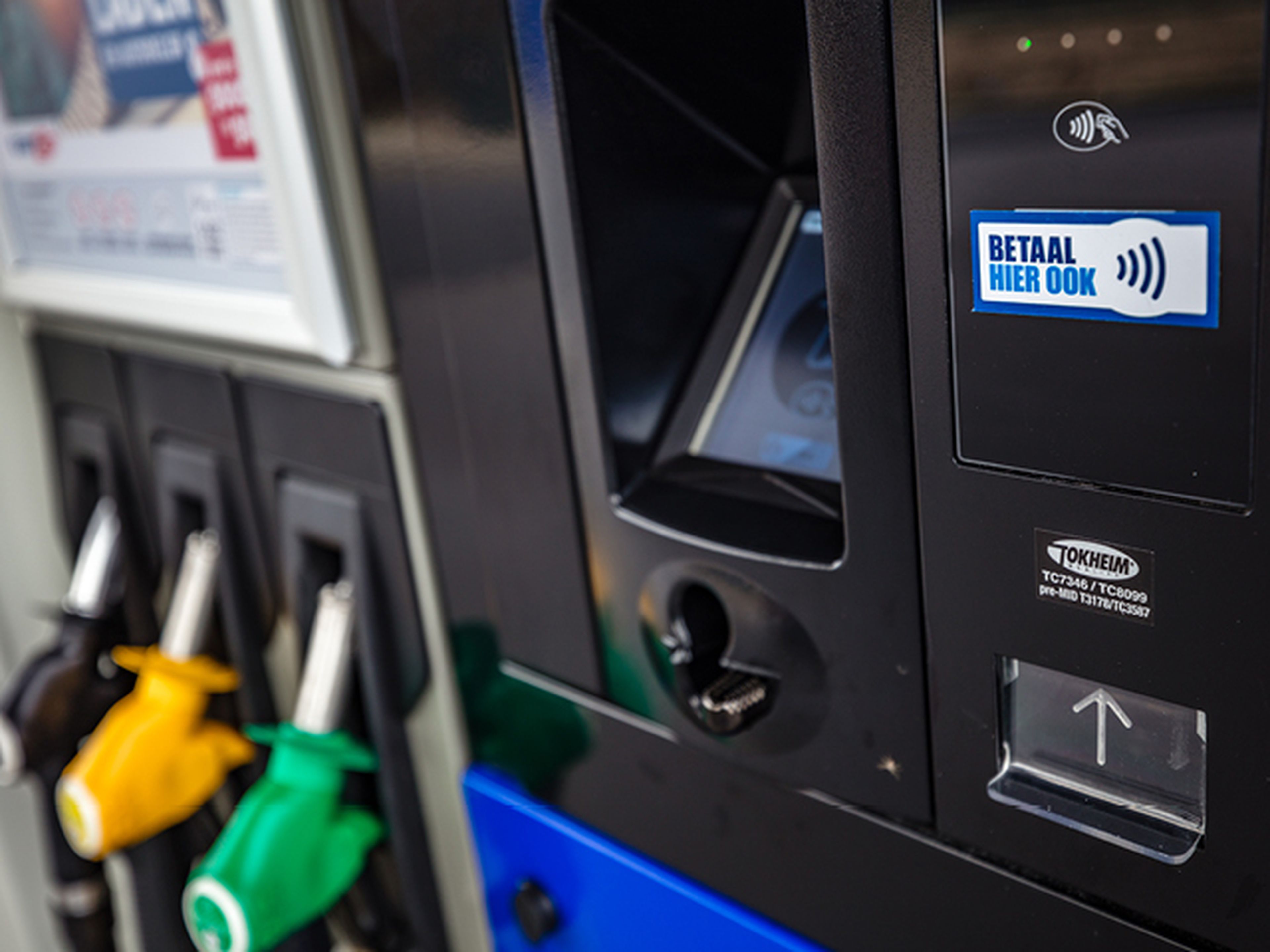 Man leunt tegen auto tijdens tanken bij Q8.
