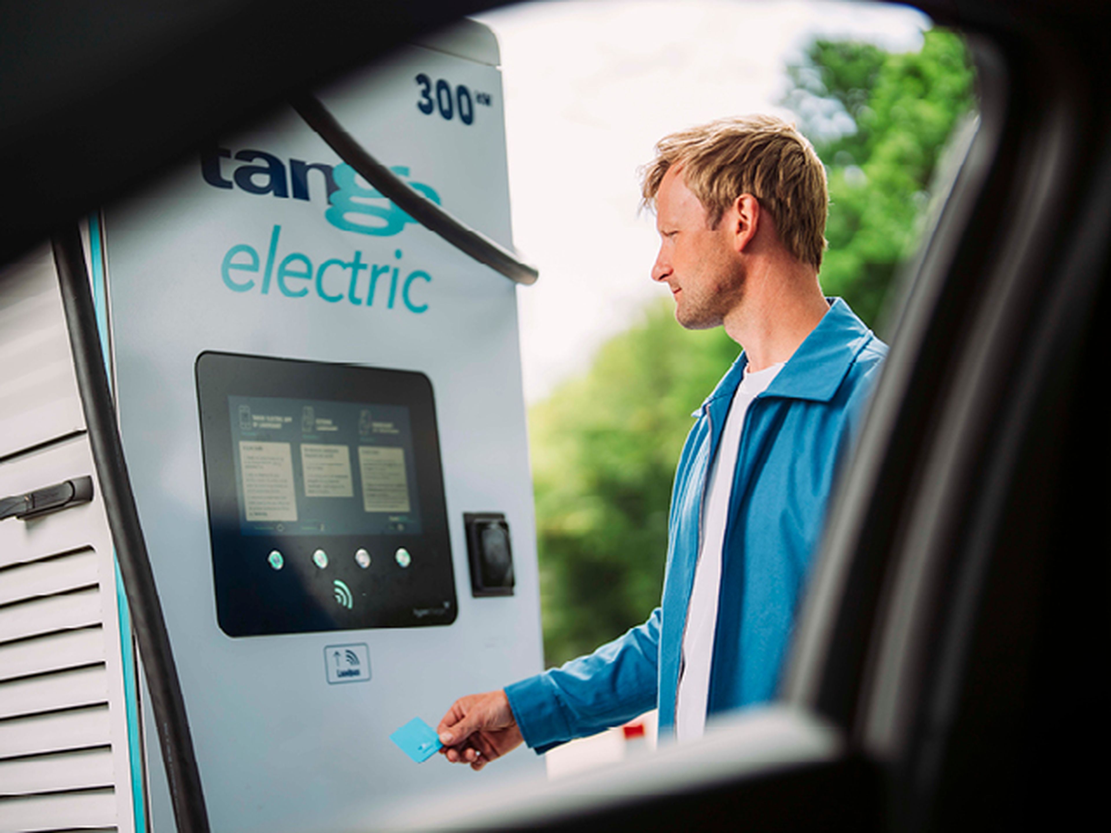 Man scant Tango electric laadpas op laadstation