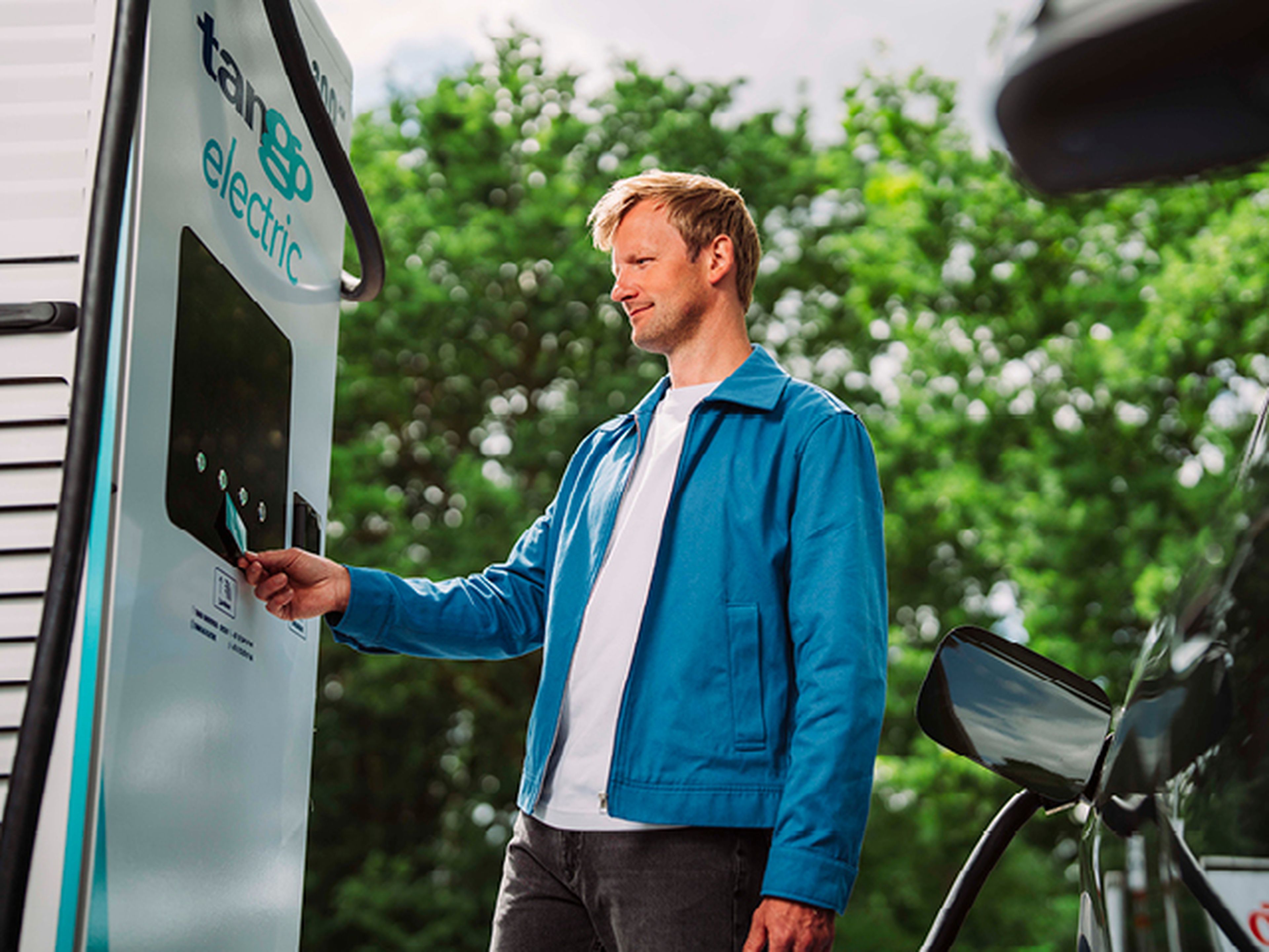 Man scant Tango electric kart bij laadpaal