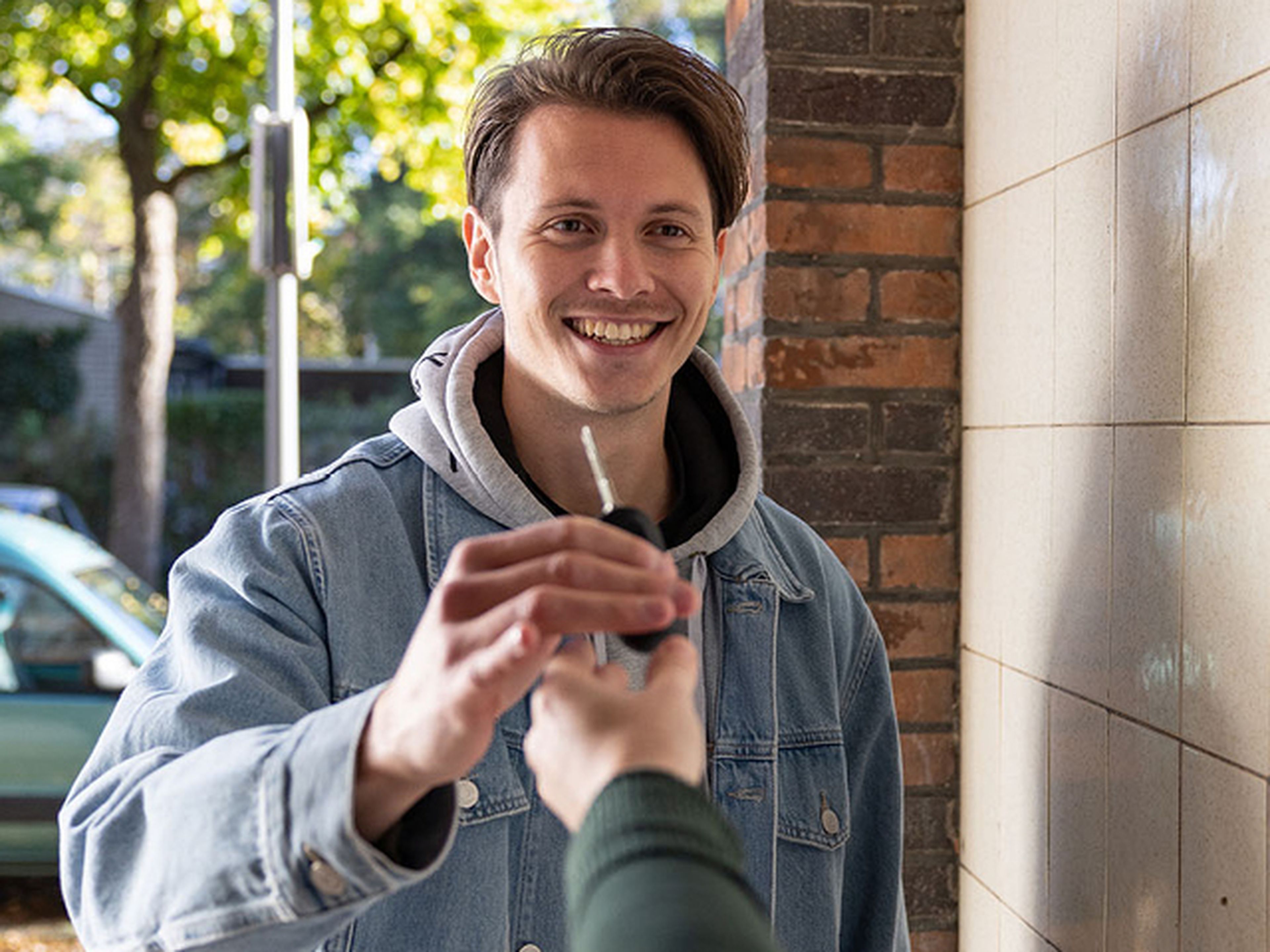 Man lacht en neemt sleutels aan