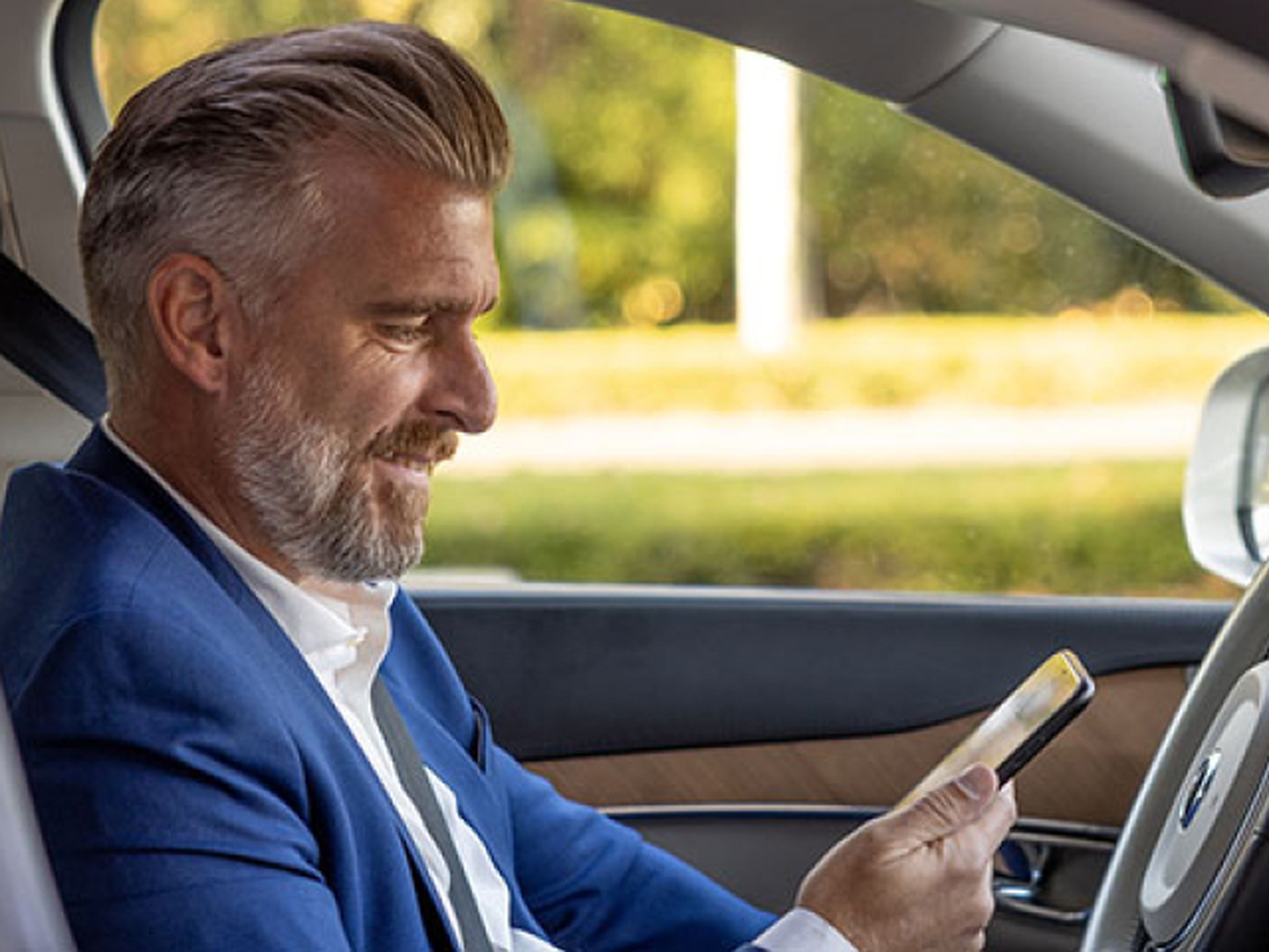 man zit in de auto en bekijkt de milo app