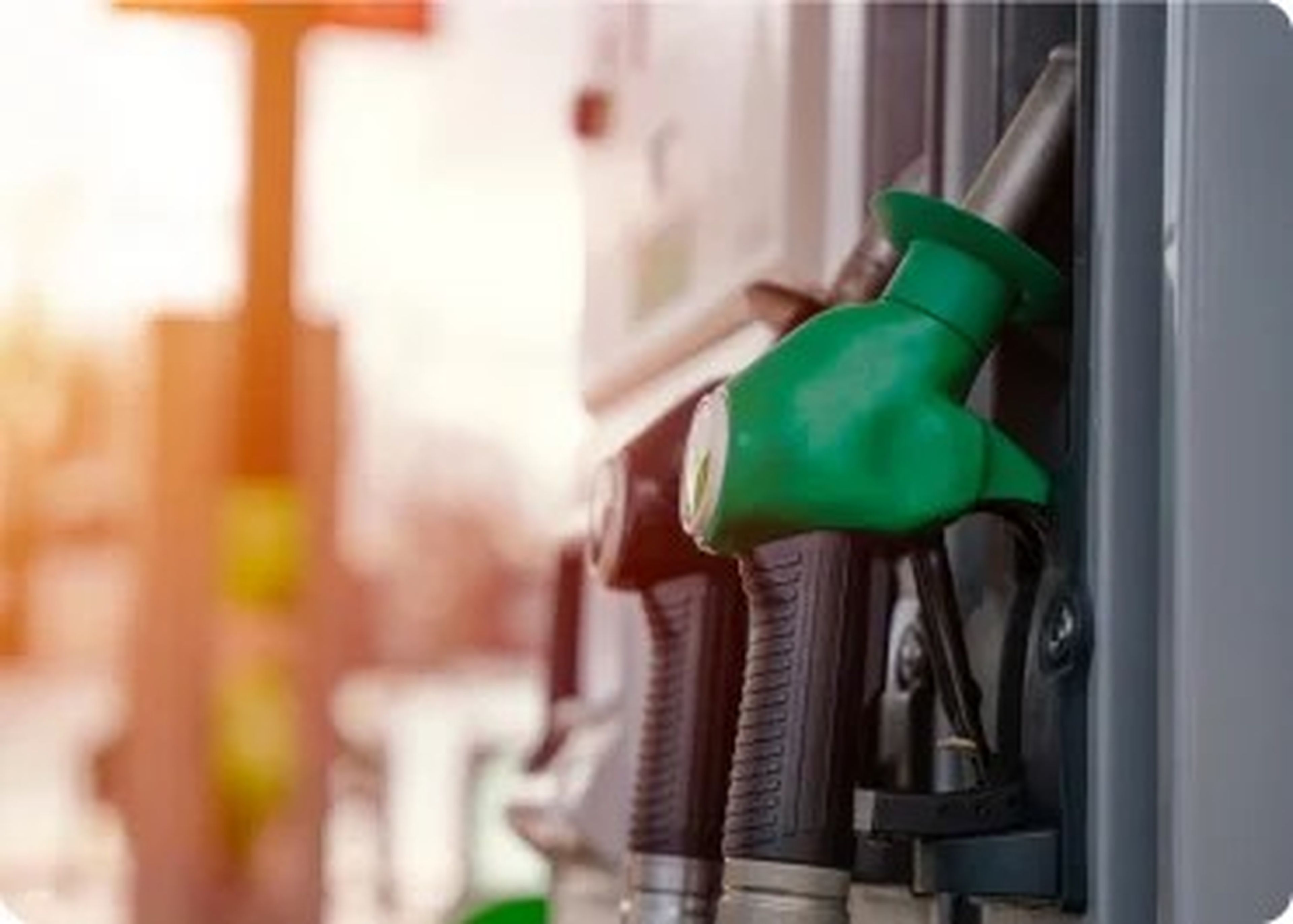 Groene en zwarte slang aan een pomp bij een tango tankstation met zonsondergang