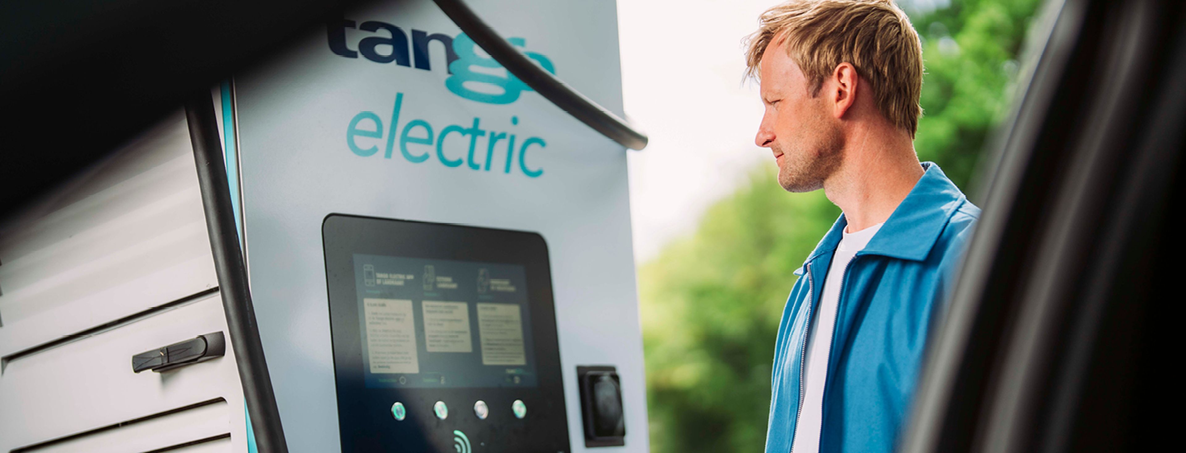 Een man houdt een tango electric laadpas tegen een Tango electric laadstation
