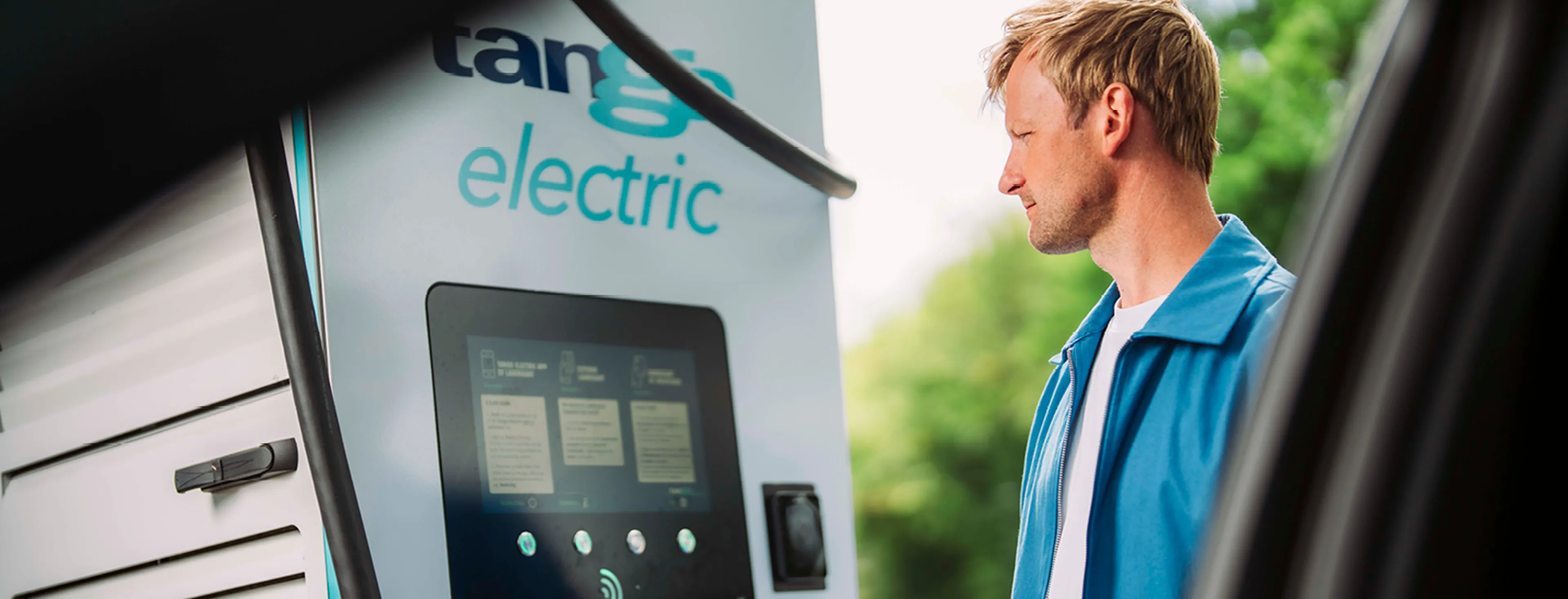 Man scant Tango electric laadpas op laadstation